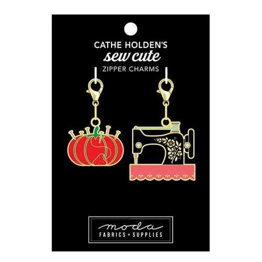 Set of two sew cute zipper charms featuring a red pin cushion and a decorative sewing machine with gold lobster hooks
