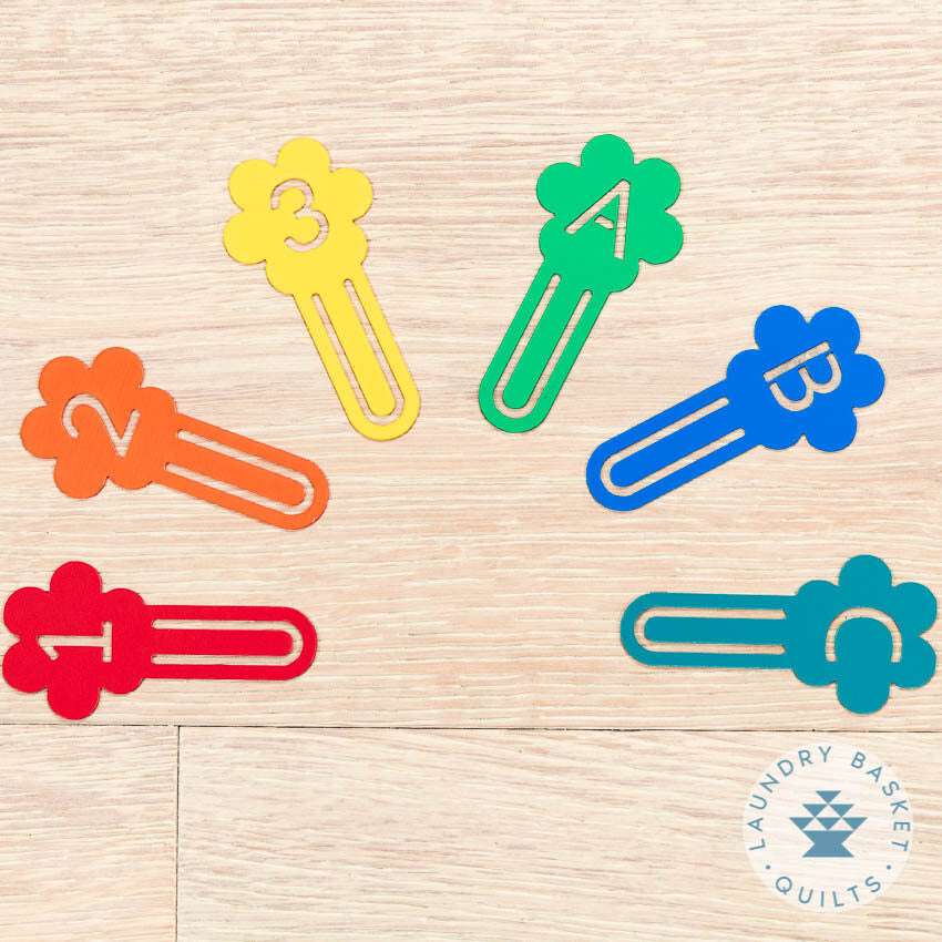 Colorful Sew Daisy Fabric Markers set with numbers and letters on flower-shaped clips for quilting organization