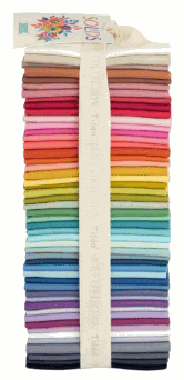 Tilda Solid Basics fat-quarter bundle with 50 multicolor fabric pieces stacked and tied with a ribbon