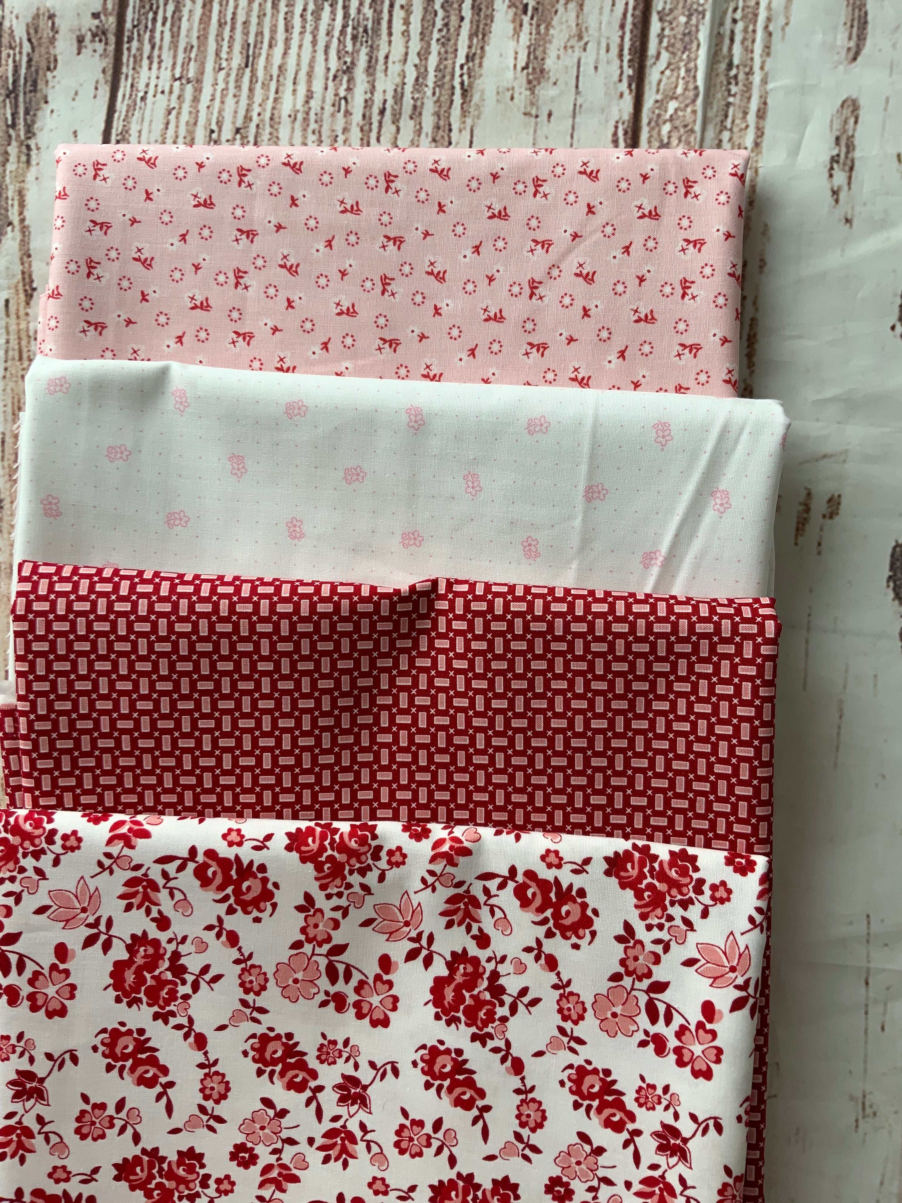 4-Yard Quilt Kit with pink and red floral and geometric fabric patterns on wooden background