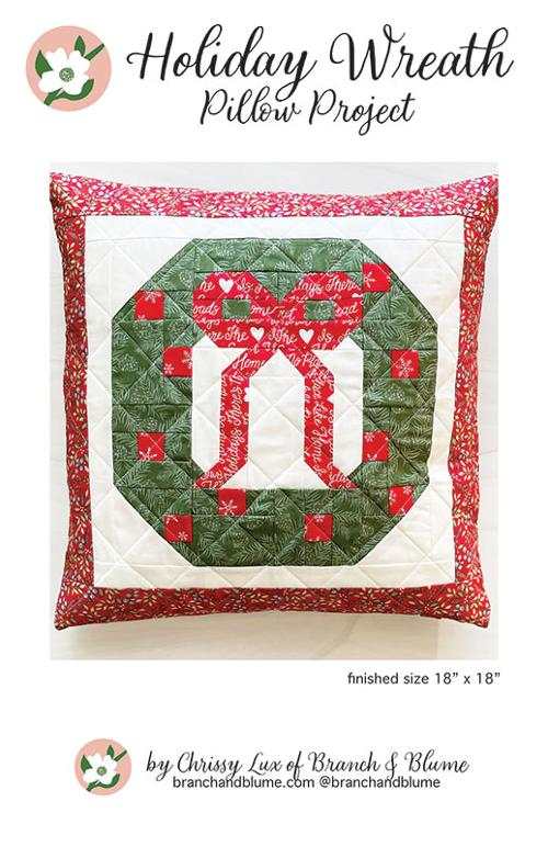 Holiday Wreath Pillow pattern with green wreath and red bow on 18x18 inch pillow by Chrissy Luxe of Branch & Blume