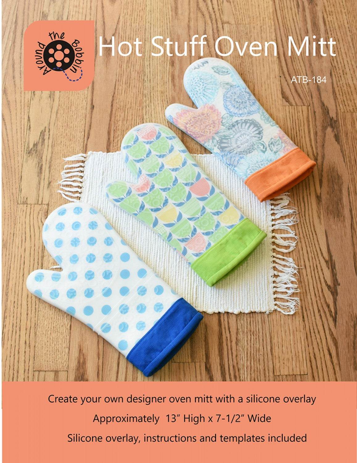 Hot Stuff Oven Mitt with colorful printed fabric and silicone overlay on wooden floor