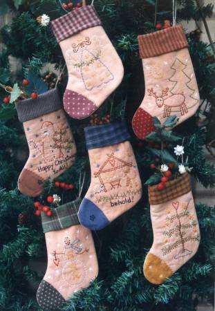 Little Christmas Stockings with embroidered designs hanging on a Christmas tree