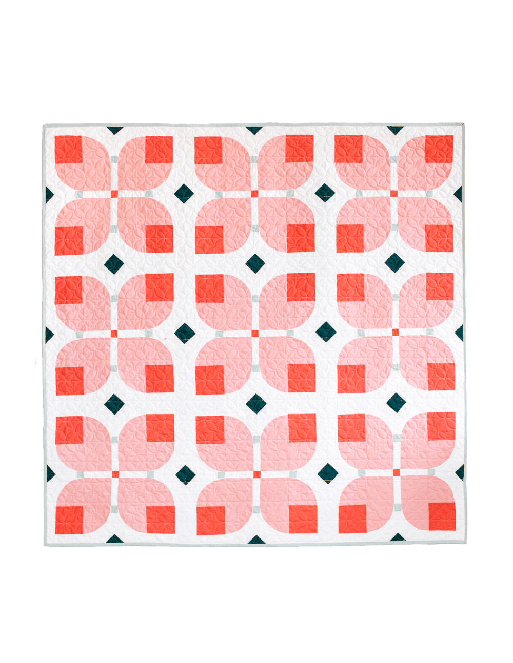 Garden Dreams quilt pattern featuring bold floral curves in pink and coral with dark green diamond accents