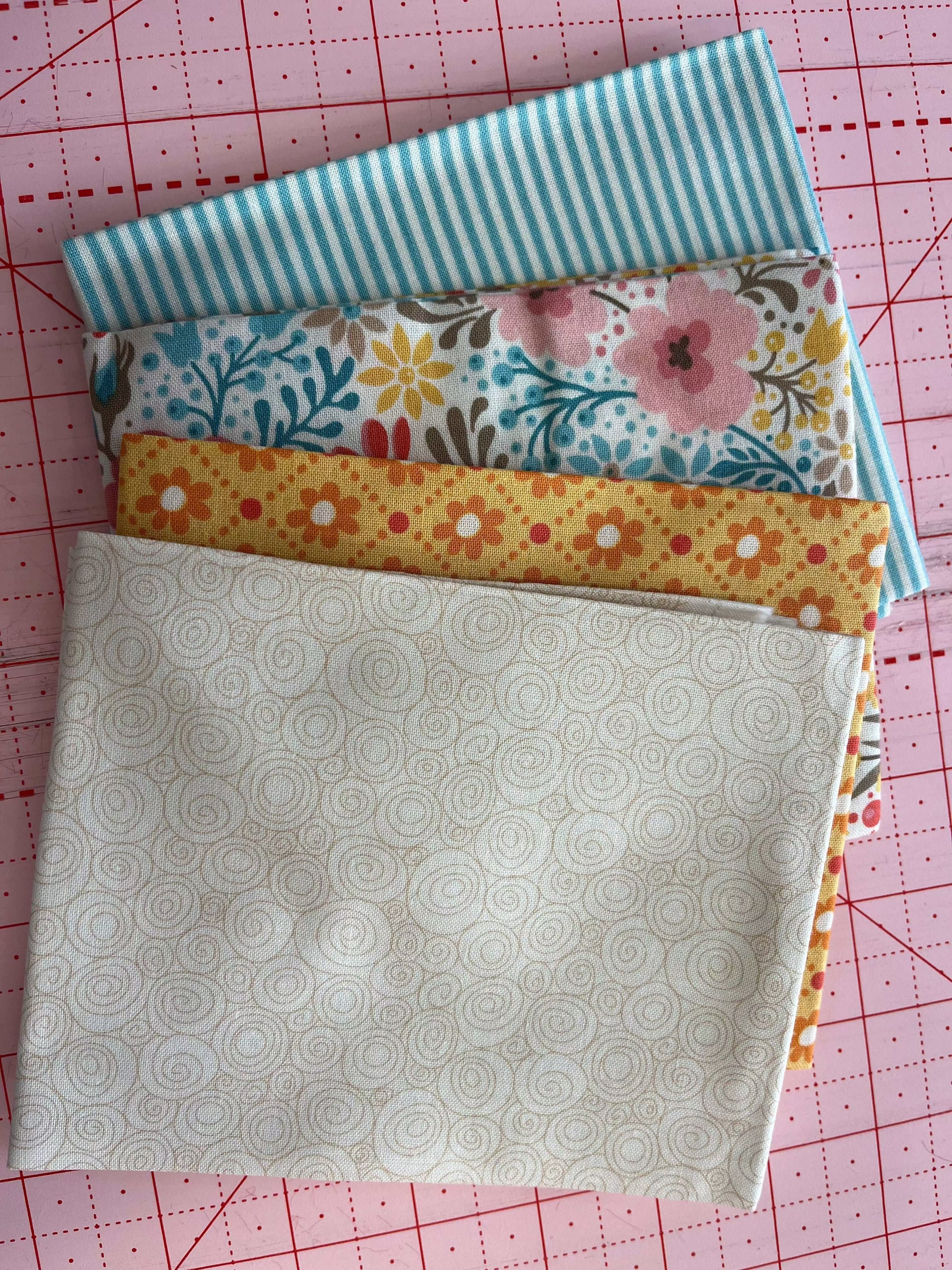 4-Yard Quilt Kit A5 with floral, striped, and patterned fabric pieces on cutting mat