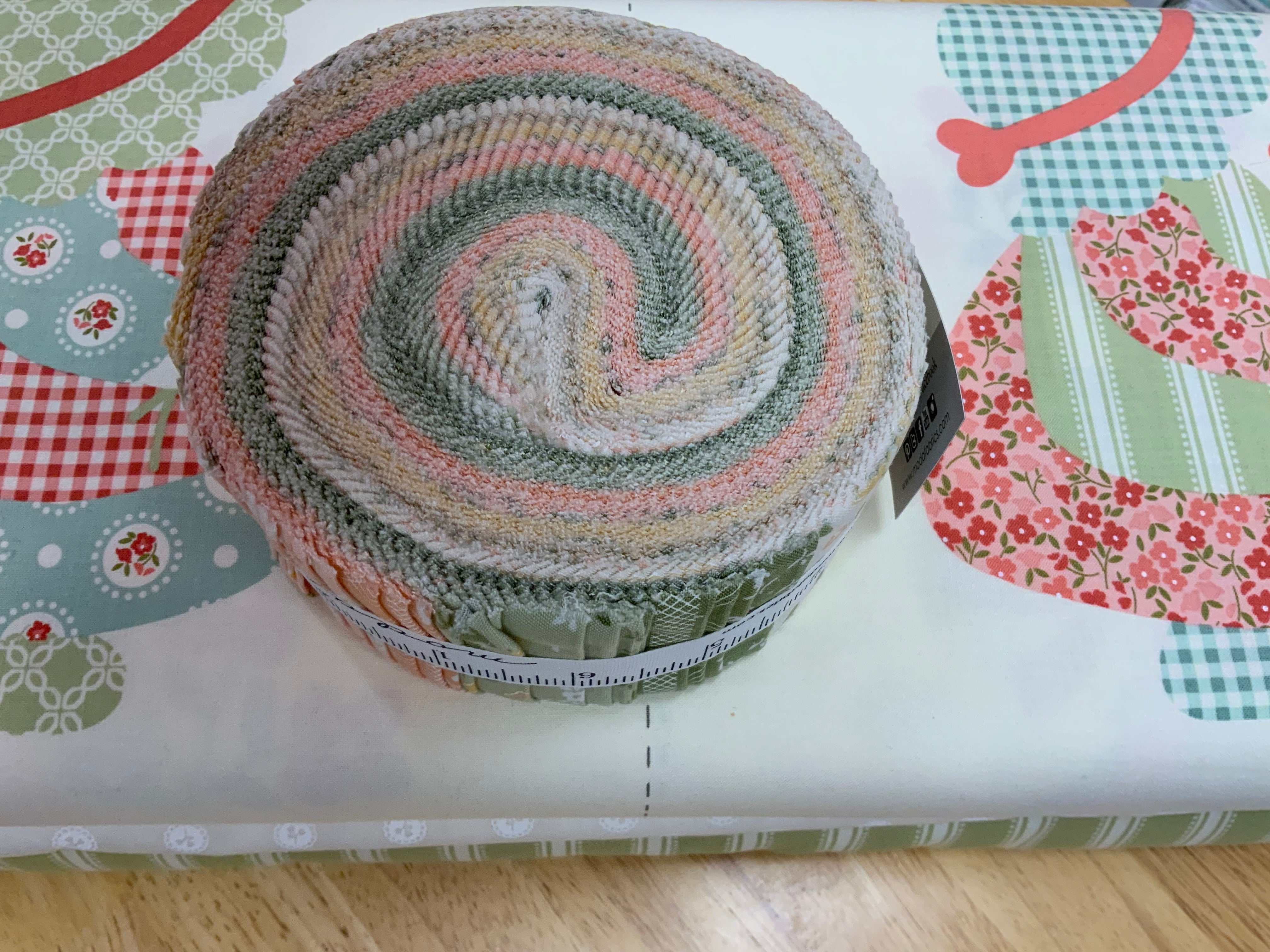 Project Jelly Roll Kit with pastel fabric rolls and Sunbonnet quilting fabric by Heather Briggs