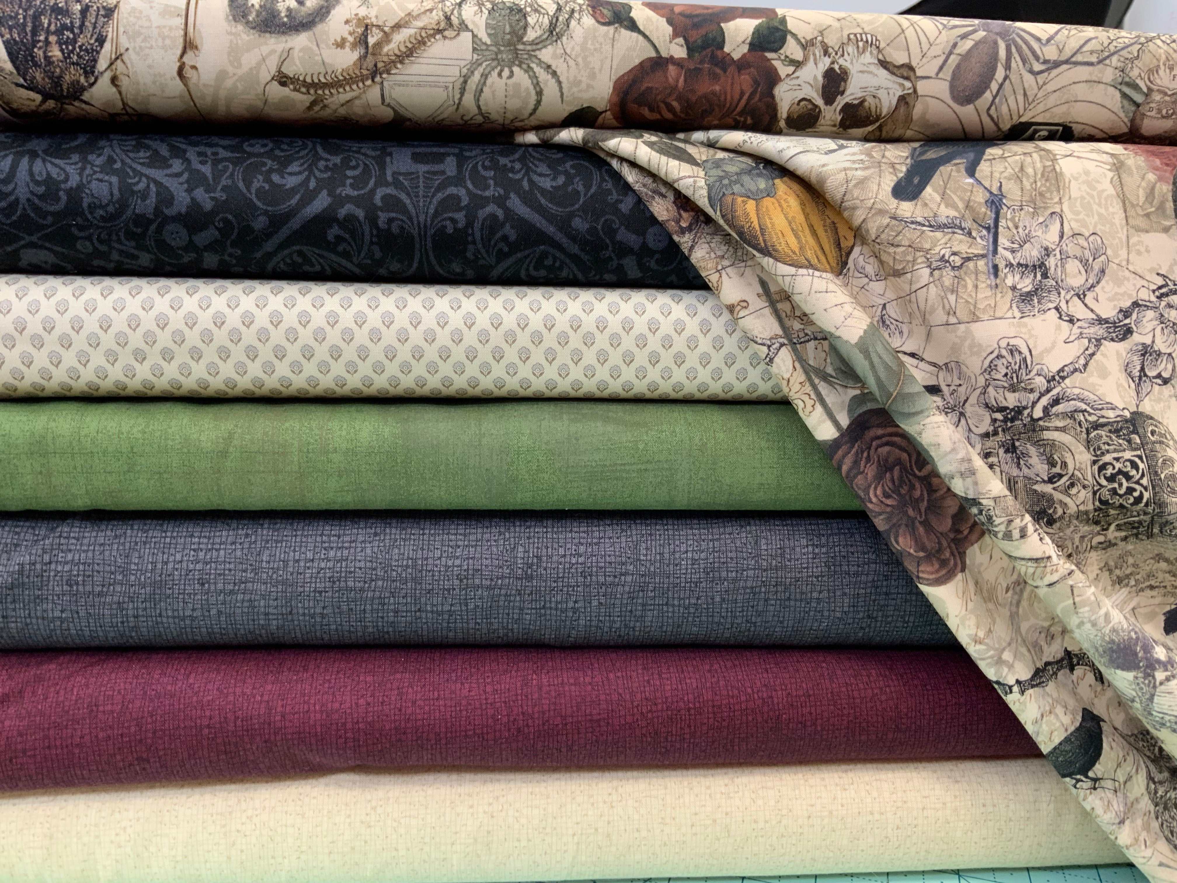 Stack of quilting fabrics in various colors and prints for M50 Island Hopping Kit by Bella Rose Quilts