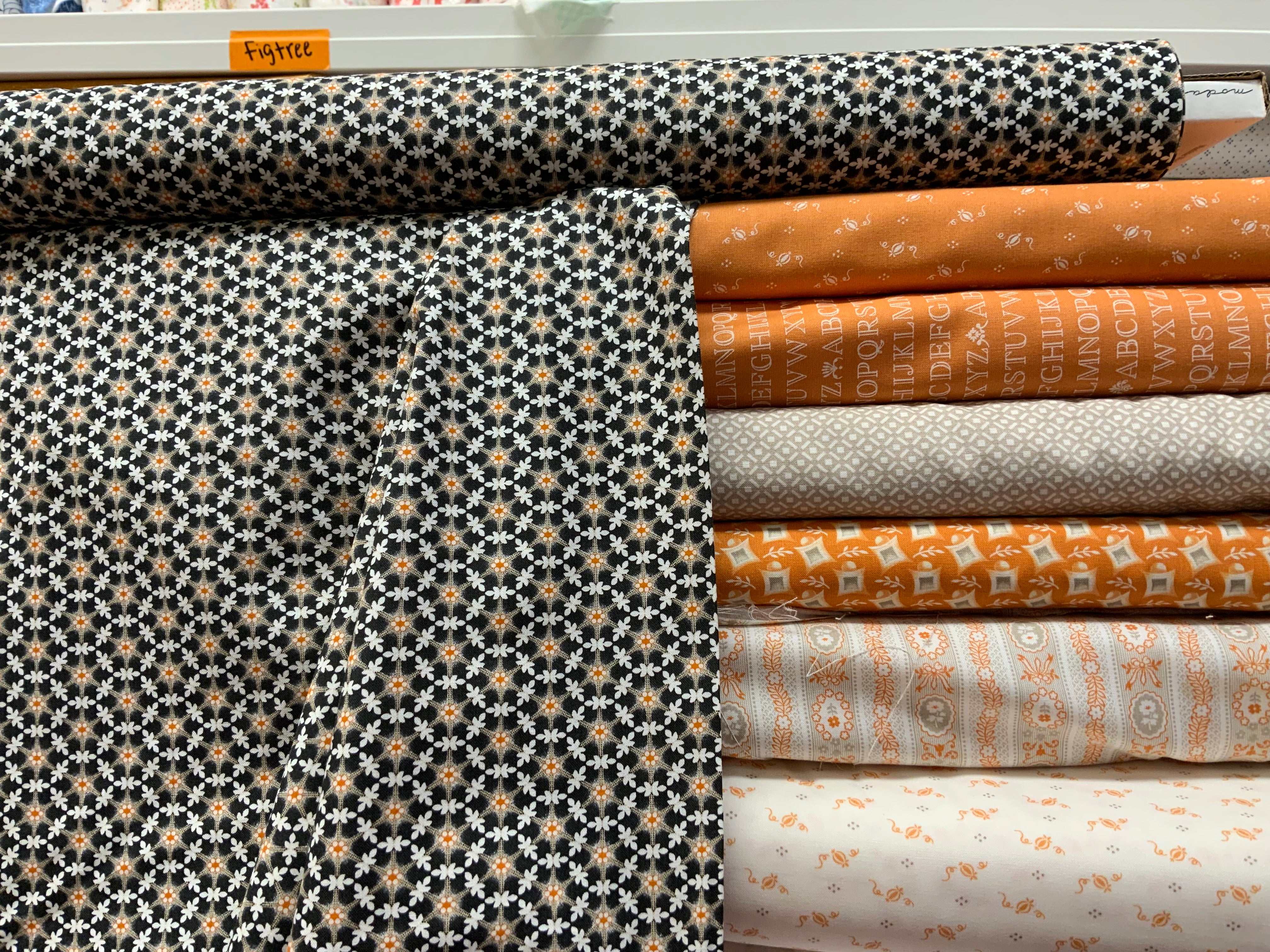 M50 Island Hopping Kit fabric stack with orange, black, and white floral and geometric quilt materials