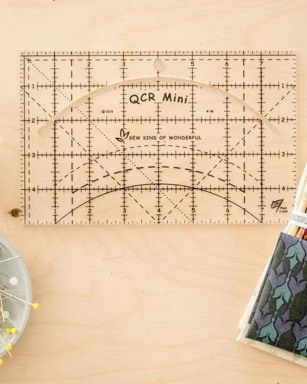 QCR Mini Ruler by Sew Kind of Wonderful acrylic quilting ruler with curved cut-out for rotary cutter, 5x8 inch size with hang hole.