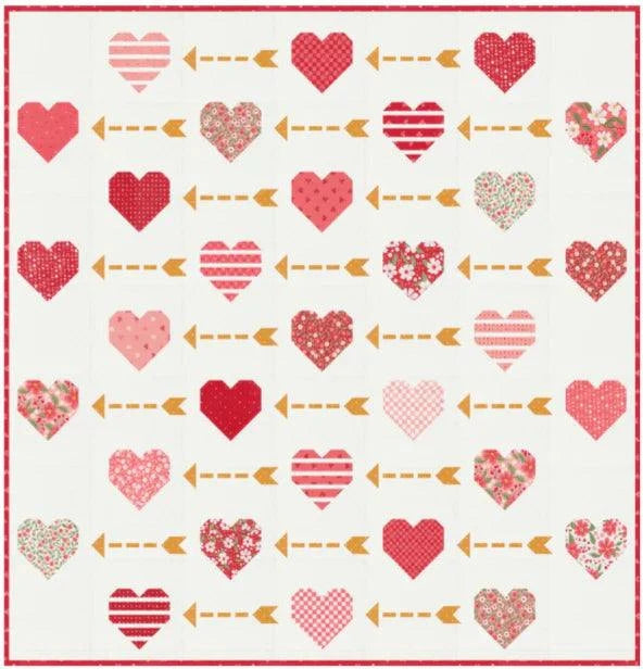 Playing Cupid Quilt Kit with heart and arrow patterned quilt top in red, pink, and floral fabrics