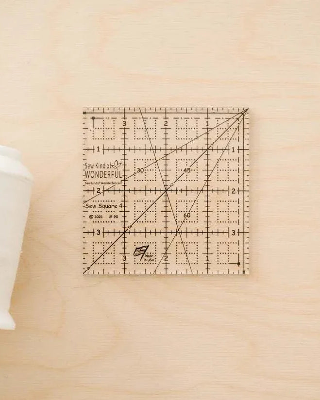 Sew Square 4™ clear acrylic 4x4 inch quilting ruler with black measurement lines and unique marks for squaring units