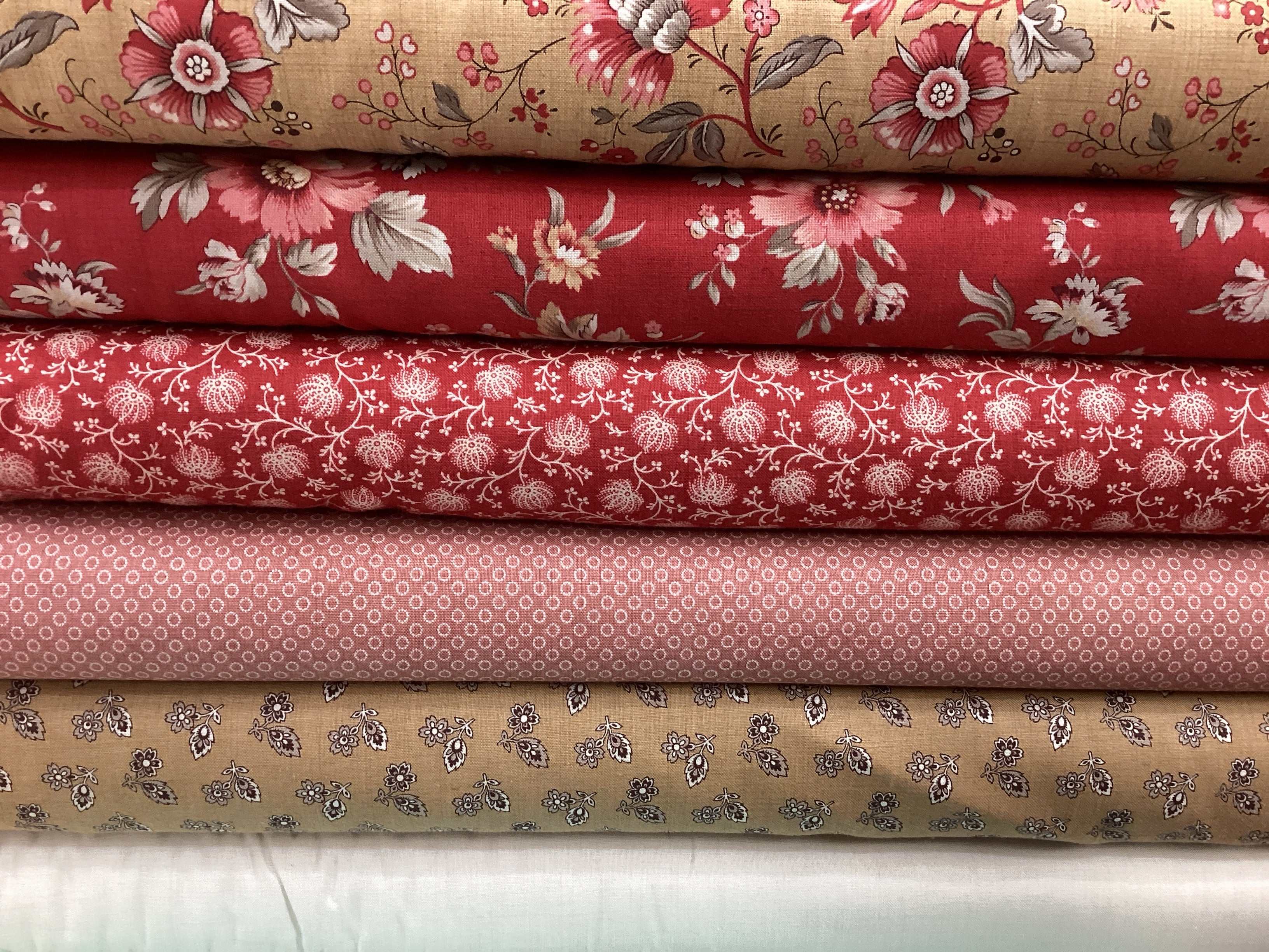 Stack of M50 Lucky Break Kit fabrics curated by Bella Rose Quilts with floral and patterned designs