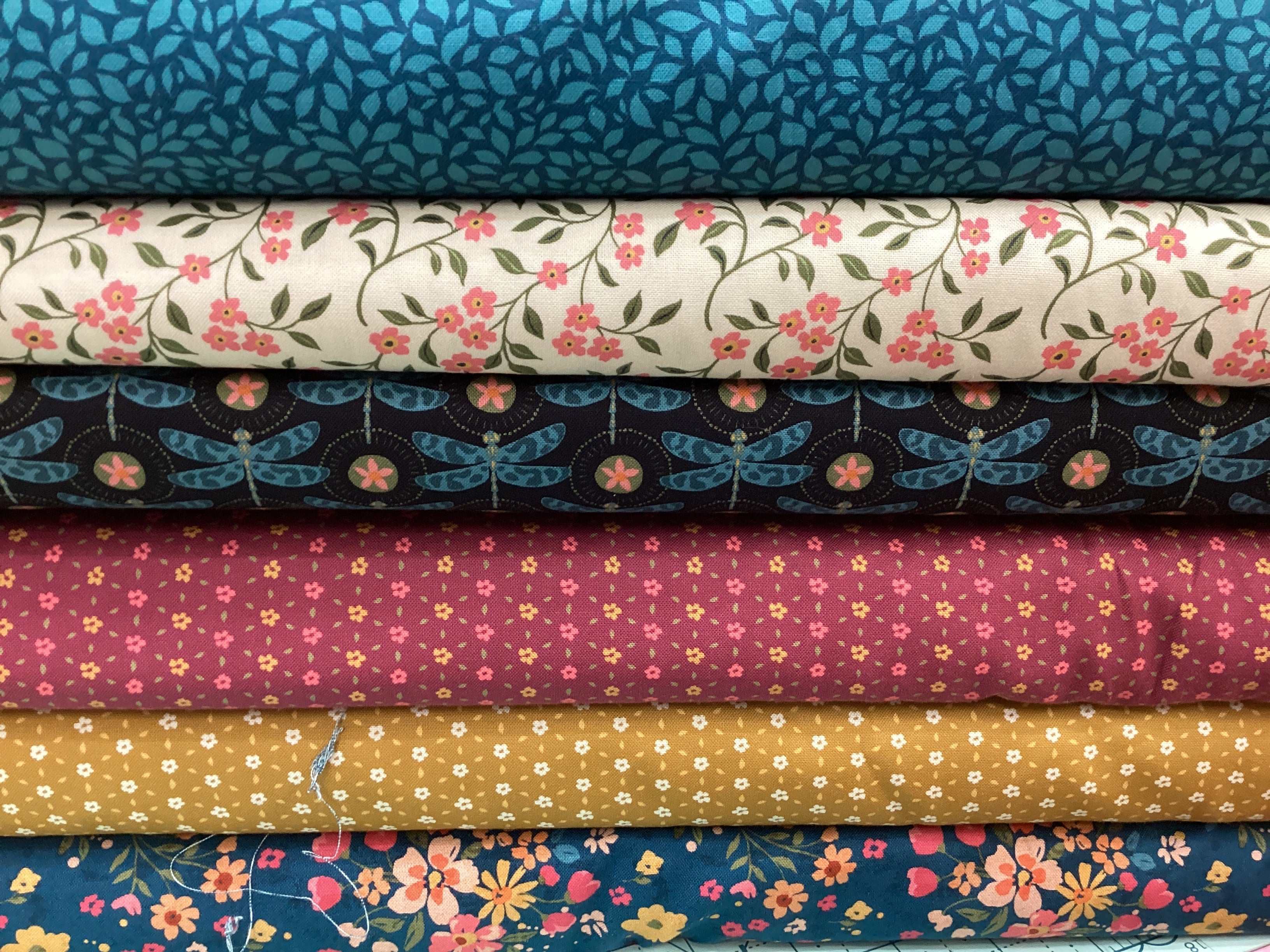Stack of floral and patterned quilting fabrics in the M50 Lucky Break Kit curated by Bella Rose Quilts