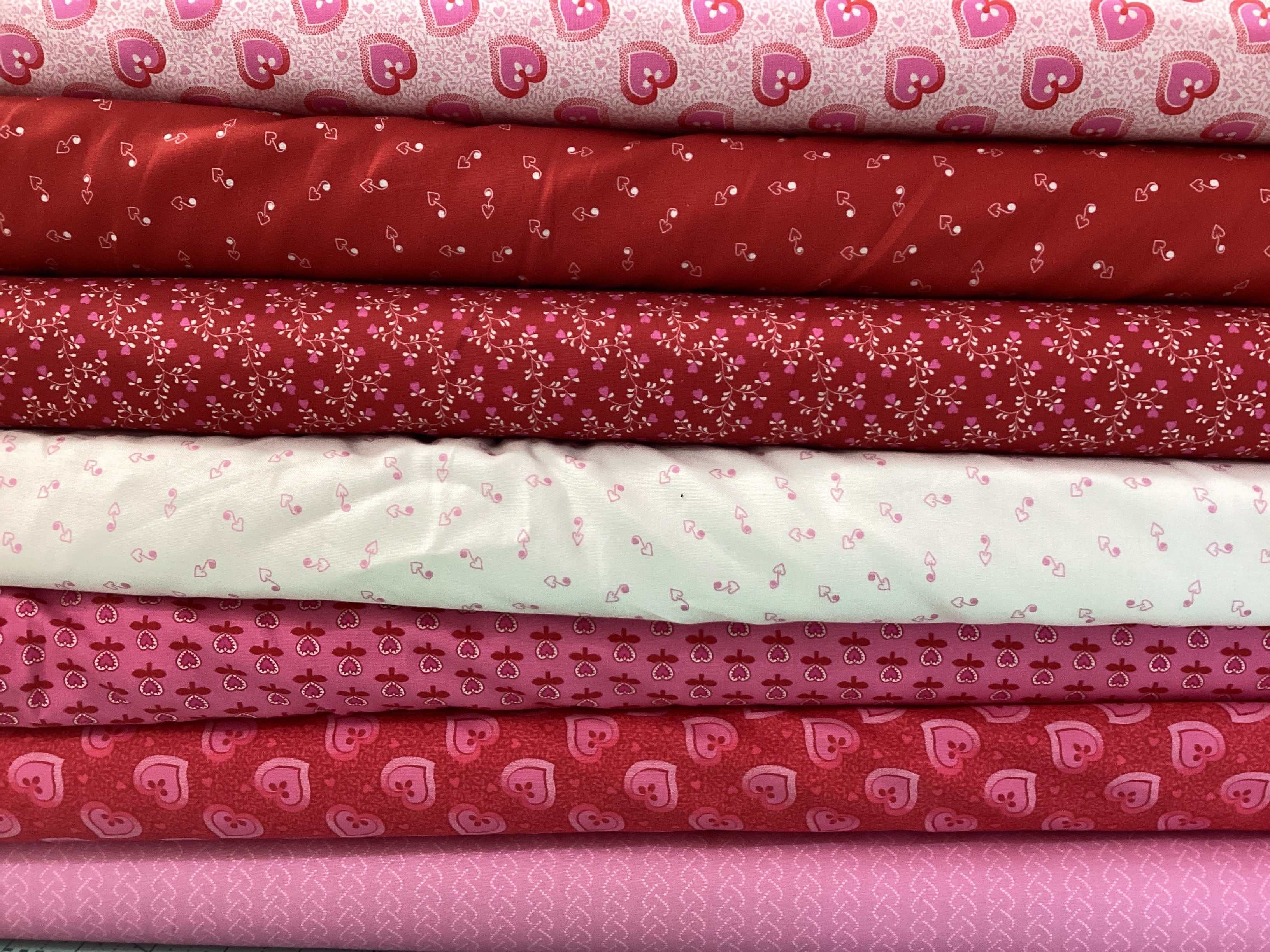 Stack of red and pink fabrics in M50 Island Hopping Kit for quilt making
