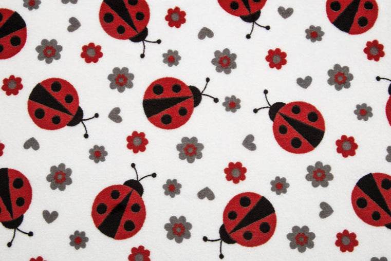 Lady Bug Digital Cuddle fabric with red ladybugs, gray flowers, and hearts on white plush minky material
