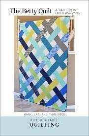 The Betty Quilt Pattern by Erica Jackowska with colorful geometric quilt design in blue, yellow, and gray tones