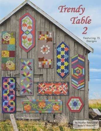 Trendy Table 2 quilt patterns displayed on barn wall with colorful geometric designs
