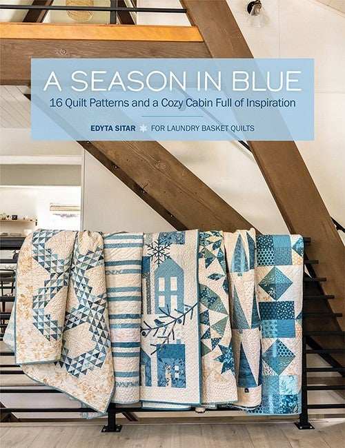 A Season in Blue quilt patterns displayed in cozy cabin setting with blue and white designs