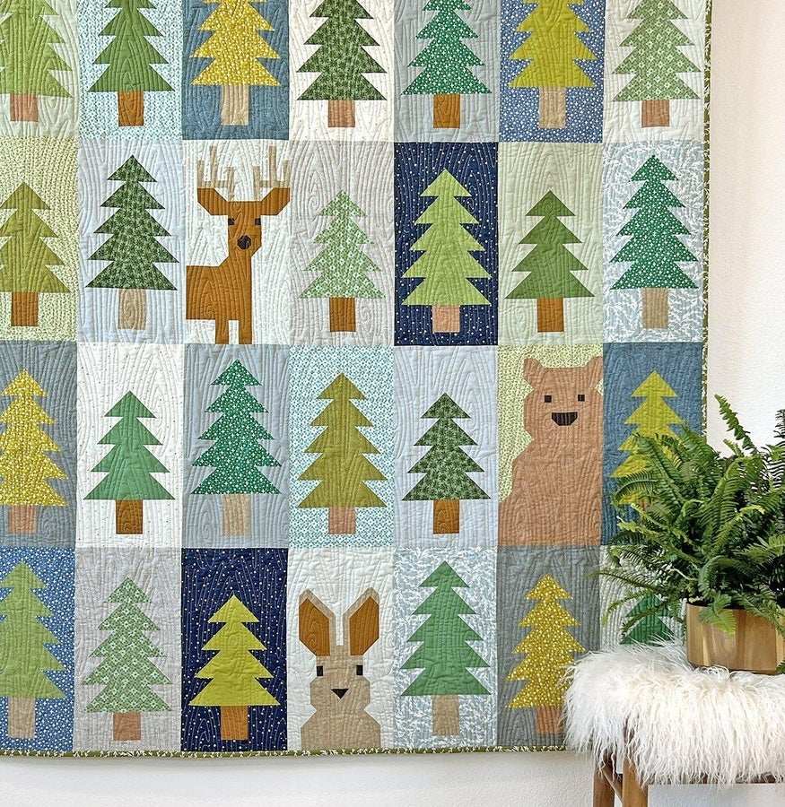 Lookout Quilt Pattern featuring forest-themed patchwork with bear, deer, and rabbit among trees.