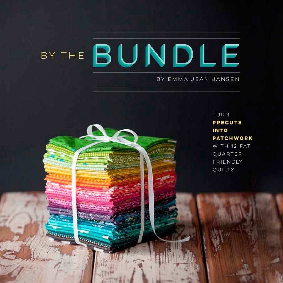 Lucky Spool By the Bundle colorful fat quarter fabric bundle tied with white ribbon on wooden surface