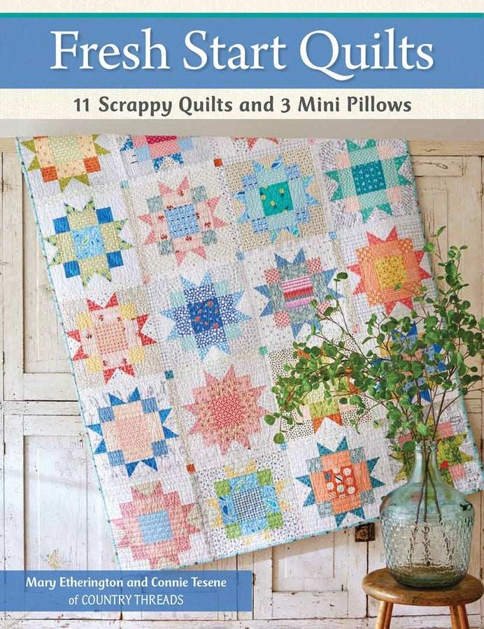 Fresh Start Quilts book cover featuring colorful scrappy quilt patterns and a glass vase with greenery on a wooden table