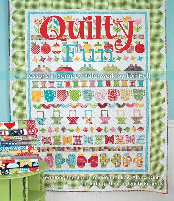 Quilty Fun book cover by Lori Holt with colorful patchwork quilt designs and stacked fabric bundles