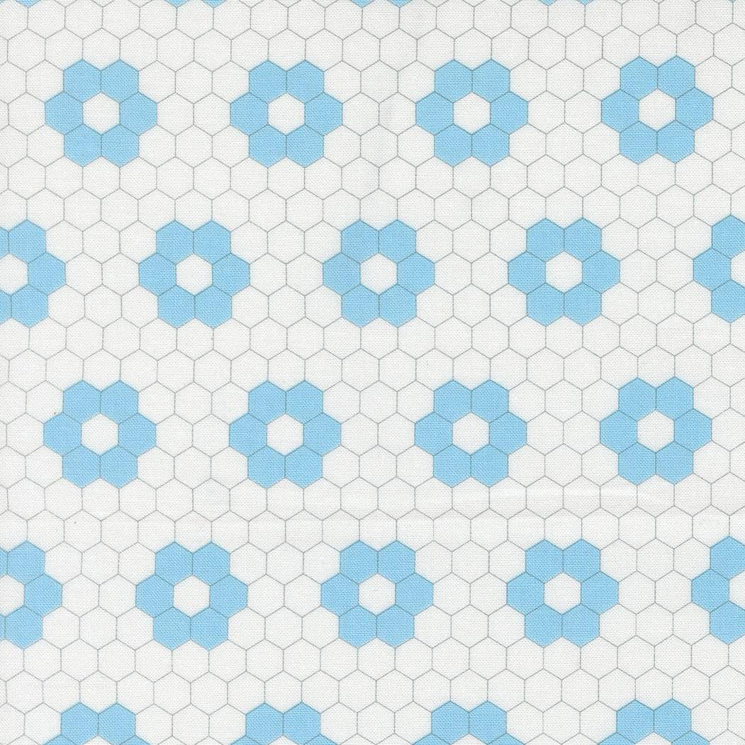 A Cat Named Stitch quilted hexagon fabric by Camille Roskelley featuring geometric cream and sky patterns
