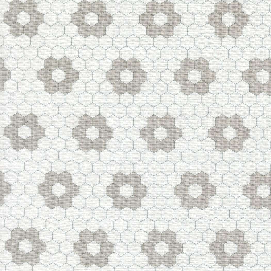 A Cat Named Stitch quilt fabric by Camille Roskelley featuring geometric cream and grey hexagons