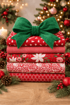 Advent Box Finishing kit stacked red fabric bundles with green bow and Christmas decorations