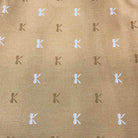 Sale Backing BB23 fabric with brown background and repeated white and dark brown "K" pattern