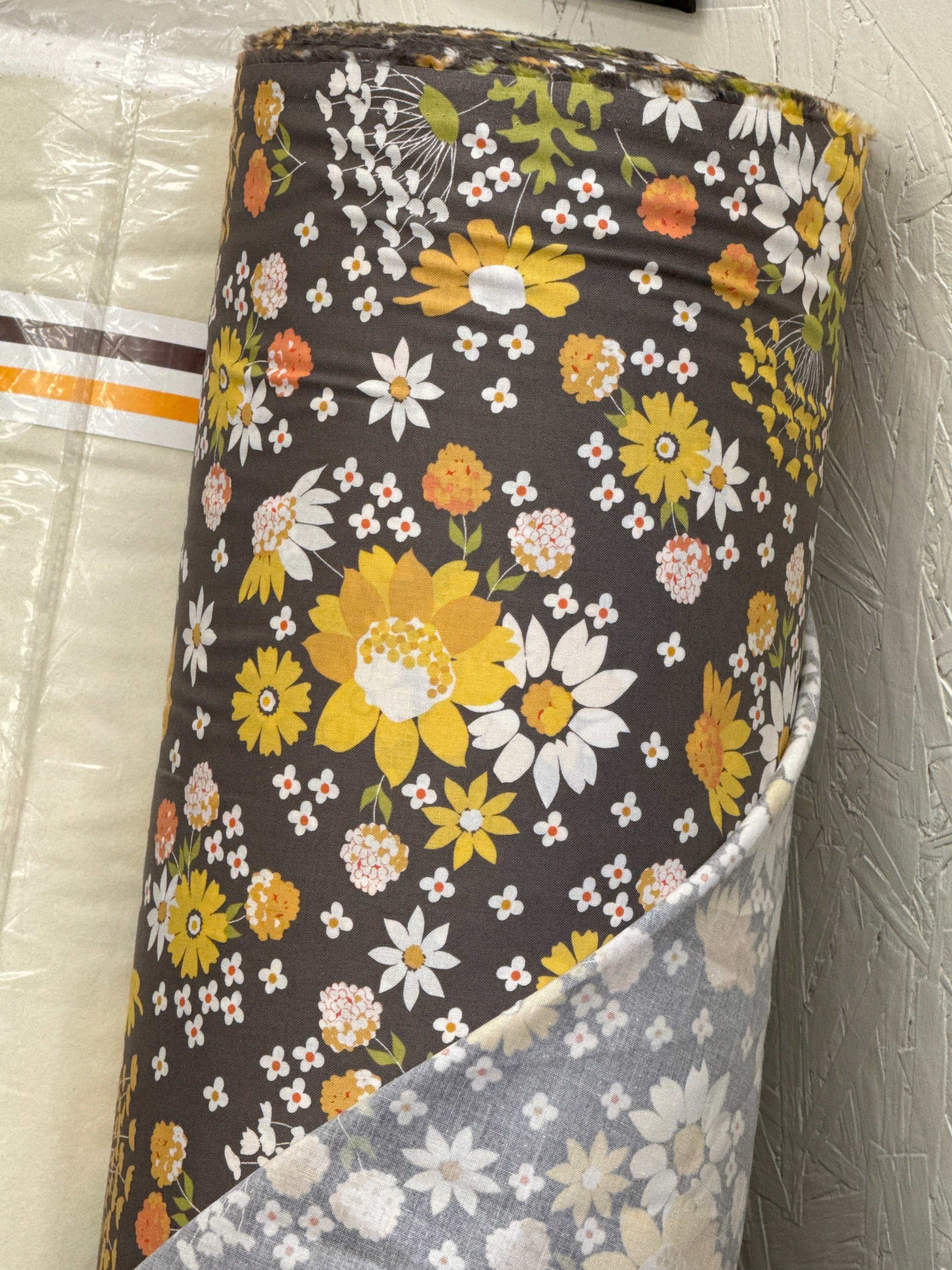 988 fabric roll with yellow and white floral pattern on dark background