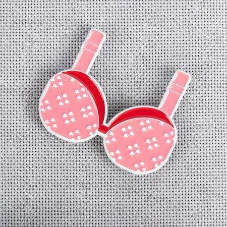 Support Group Enamel Needle Minder in pink bra design on grey fabric background