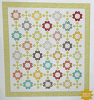 Garden Melody Quilt Kit with colorful floral patchwork and green border, 68x76 inches.