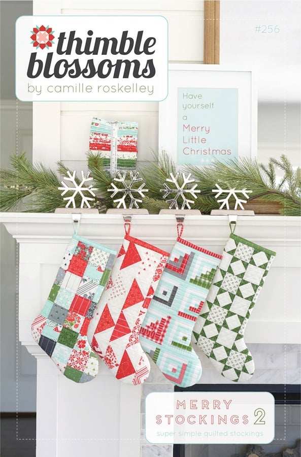 Merry Stockings 2 Quilt Pattern colorful quilted Christmas stockings hanging on mantle with snowflake decorations