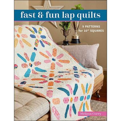 Cozy colorful lap quilt made from 10-inch squares on a couch, featured in Fast & Fun Lap Quilts by Melissa Corry