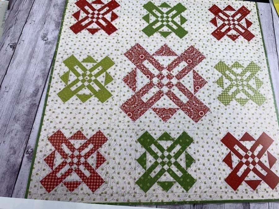 Bridgerton 40-1/2" Table Topper with red and green quilted geometric patterns on a light background